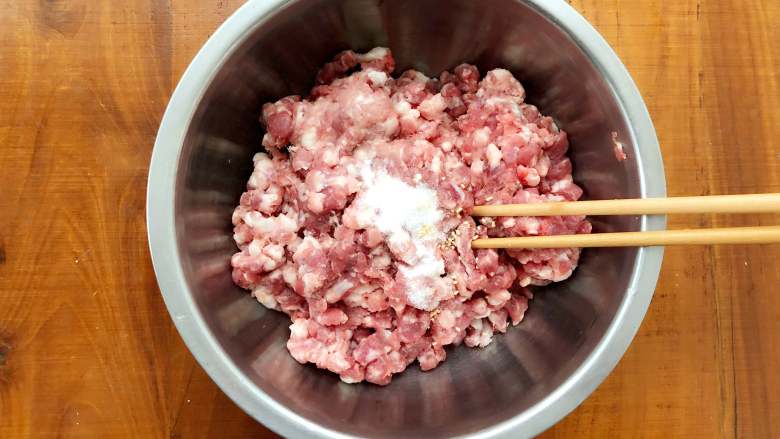 玫瑰花抱蛋煎饺,醒面团的过程中,来调制饺子馅。首先在肉馅里加入盐,使劲朝一个方向搅拌,直至搅拌至肉上劲。