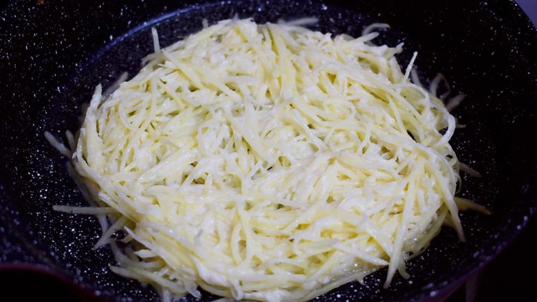快手土豆饼,平底锅倒入适量的食用油烧热,把土豆丝放入,整理成圆形