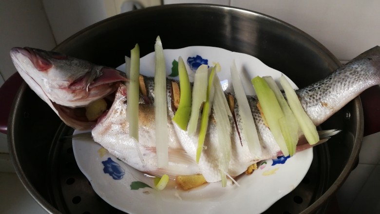 清蒸海鲈鱼,蒸锅水开放入海鲈鱼蒸八分钟,焖三分钟