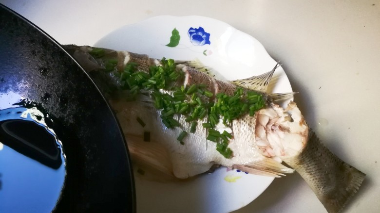 清蒸海鲈鱼,取出海鲈鱼去掉大葱,姜片,放上葱花,锅中烧热适量<a style='color:red;display:inline-block;' href='/shicai/ 850'>大豆油</a>淋在葱花上