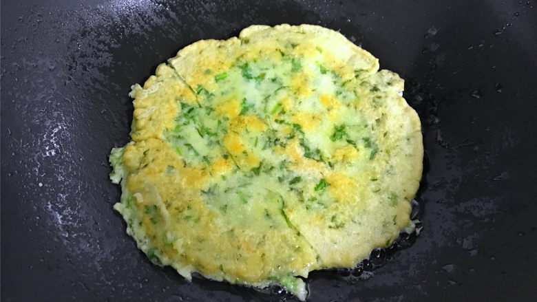 茼蒿鸡蛋饼,一面煎好后翻面再煎另一面,煎至两面呈金黄色后出锅。