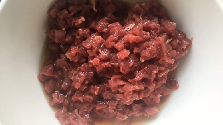 香菇牛肉辣椒酱,将切好<a style='color:red;display:inline-block;' href='/shicai/ 216'>牛肉</a>丁装碗内,加料酒搅拌均匀,腌制半个小时