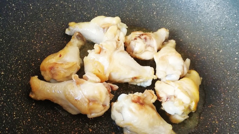 翅根香菇焖饭,炒锅内倒适量的食用油烧热,下入鸡翅根煸炒至表皮微微焦黄。