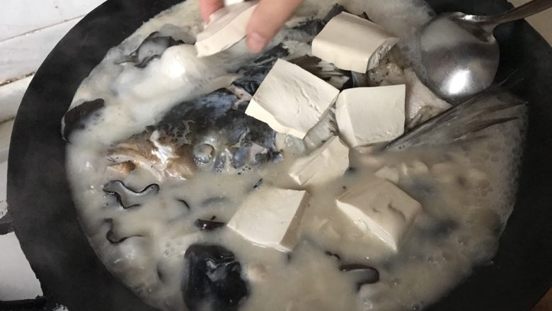 鱼头汤,放入豆腐。盖上锅盖,炖煮10分钟