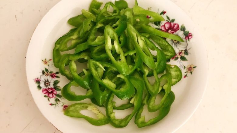 杂蔬腊肠炒饼,把尖椒去蒂去籽,切成辣椒圈
