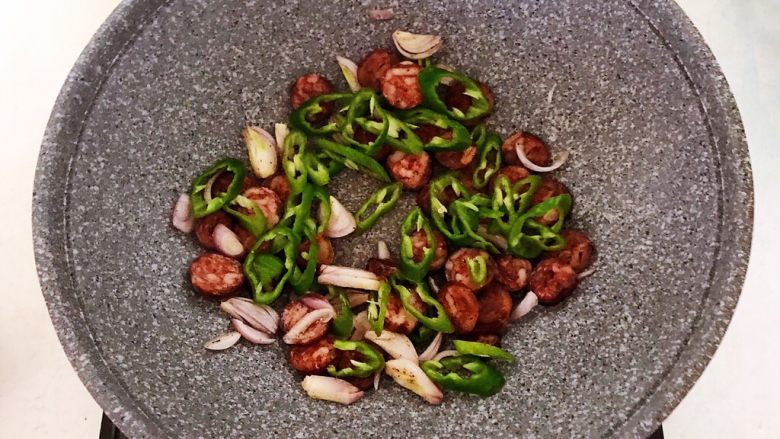 杂蔬腊肠炒饼,加入尖椒,翻炒均匀