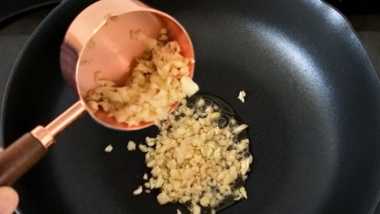避风塘炒虾,下蒜蓉,煸炒至微微发黄。
