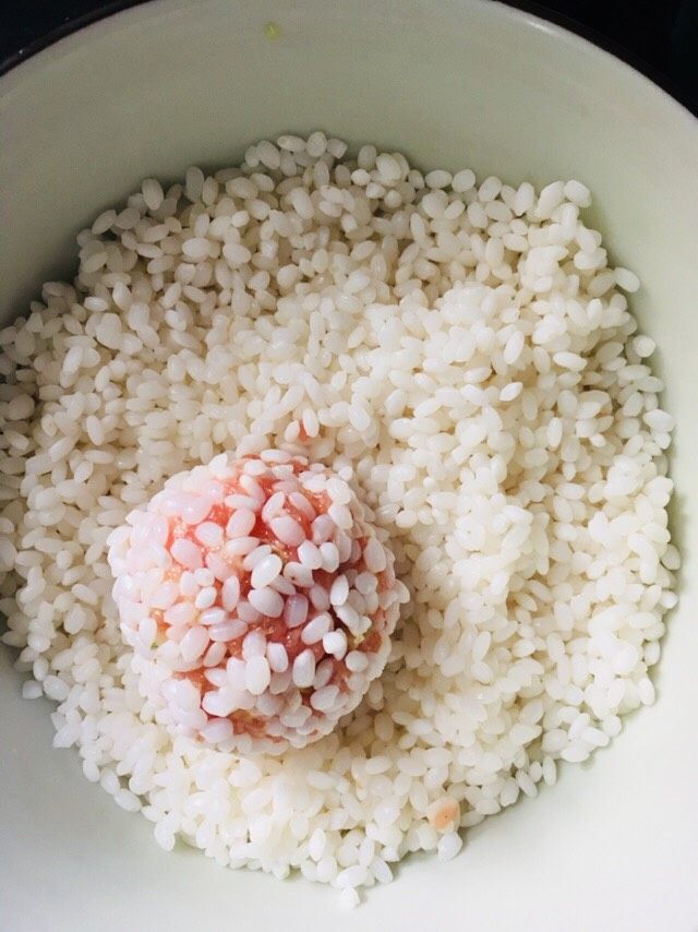 珍珠丸子,抓大约30克左右的肉末做成丸子后放入盛糯米的容器里滚几圈,直到肉丸子均匀地裹上糯米即可