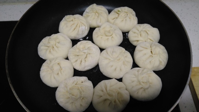 猪肉芹菜水煎包,不粘锅中放入少量油,放入包好的包子,小火煎至底面金黄,可以移动锅子~使每一个包子都受热均匀,底部金黄。