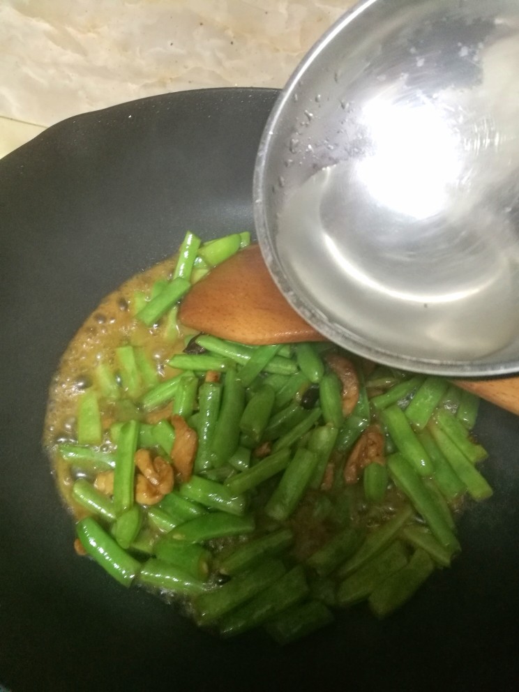 豆角炒肉段,锅中放入适量清水,豆角要小火多炒一会