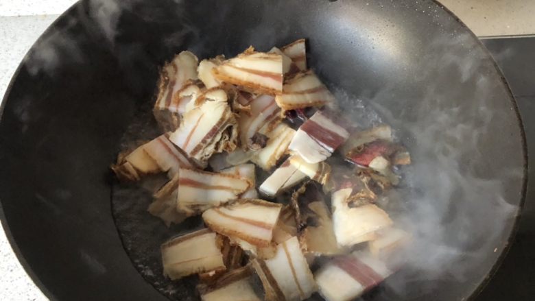 蒜苗炒腊肉,腊肉切薄片,放入锅中,加少许水,盖盖子闷煮几分钟。主要是将肉煮熟,也可以直接把肉块煮熟了再切。