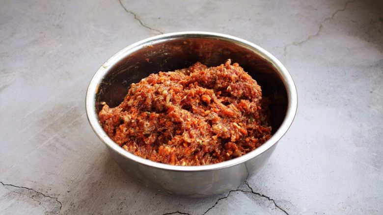 胡萝卜牛肉馅饺子,最后放入1勺的盐,将肉馅搅拌均匀备用。