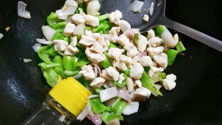 泡椒洋葱炒鸡丁,放入鸡丁,淋入一勺料酒