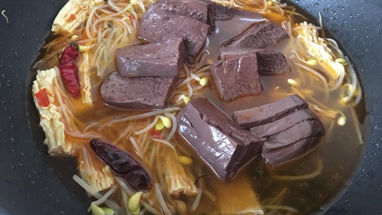 麻辣豆芽炒鸭血,放入鸭血后,小心翻炒,把鸭血尽量泡在汤汁里,大火烧开后转小火一分钟,关火焖二分钟,这样鸭血才入味。
