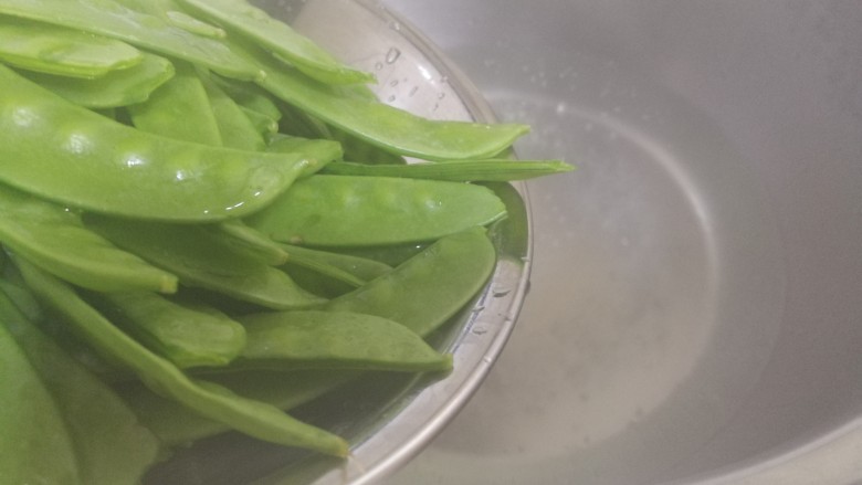 肉炒荷兰豆,热水下锅,将荷兰豆焯一分钟。只焯一分钟。可去焯除荷兰豆的豆腥味儿。焯好,捞出控水。