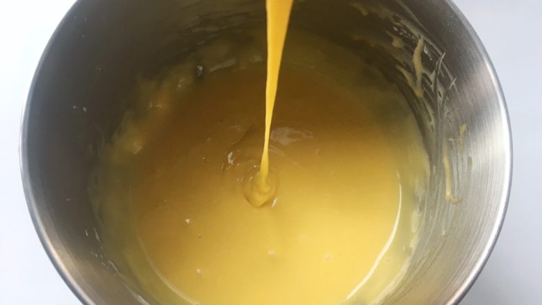 依云米奇蛋糕卷,用蛋抽画Z字将蛋黄跟面糊搅拌均匀,面糊细腻顺滑