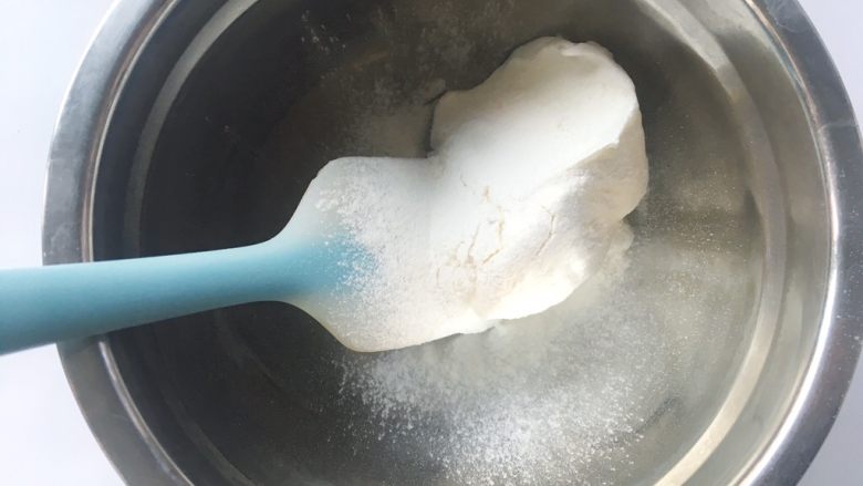 依云米奇蛋糕卷,准备一个干净的容器,取一小份蛋白霜,过筛上一点点低筋面粉,搅拌均匀,剩下的蛋白霜放冰箱冷藏备用,预热烤箱160度