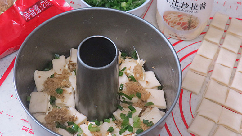 咸口好味滴【青葱肉松手撕包】,一层码在模具里,挤一圈蛋黄酱,撒上香葱和肉松,再叠加一层小面块,加蛋黄酱香葱肉松,依次重复