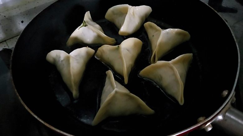 营养早餐1210之鸡蛋抱饺,小火煎至饺子金黄,加入水到饺子一半的位置,盖上锅盖。