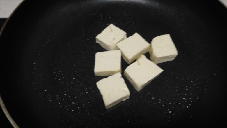 豆腐炒平菇、金针菇,不粘锅中放入适量油,放入豆腐块。