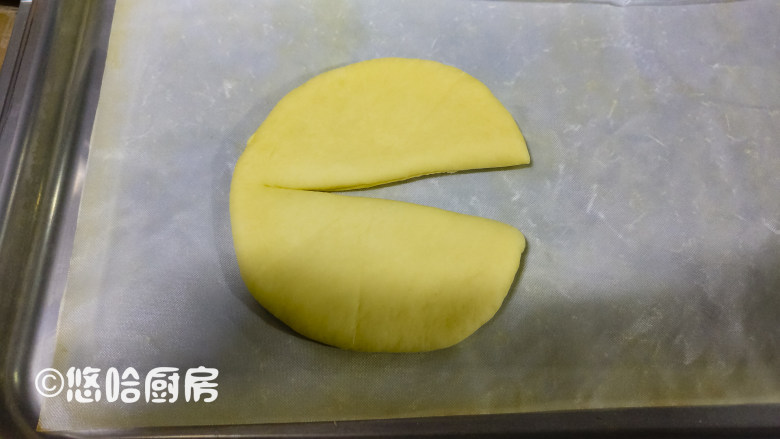 圣诞树面包,醒发后的面团,先从重量最大的开始整形。面团按压拍扁,擀开成圆形,用刮板在面团上压出6等分的痕迹,用刮板在面团的中间切开,但不要切断,把切口展开。