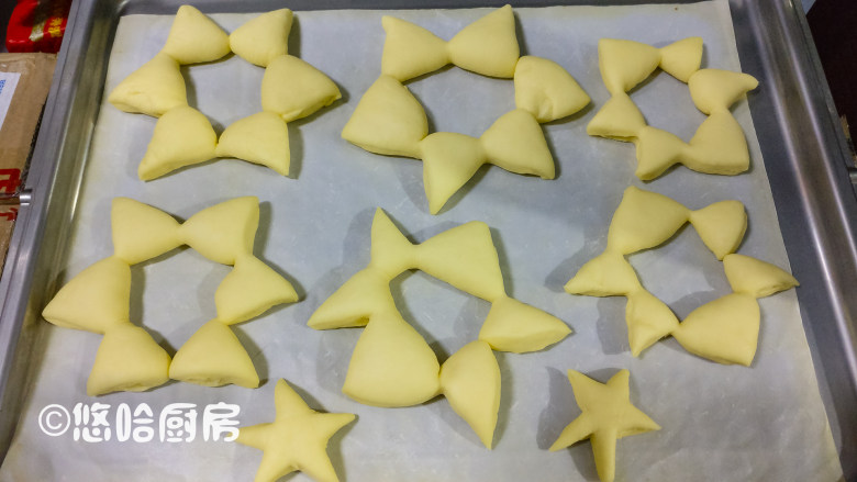 圣诞树面包,烤盘放在烤箱中,表面盖保鲜膜,在烤盘下面放一碗热水,让面团在密闭温暖的环境中进行二发,一个小时面团发酵到位。