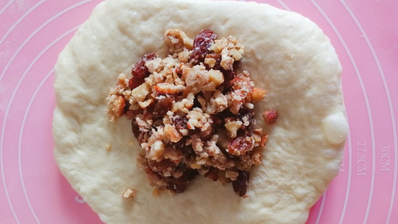 坚果吐司面包～波兰种,把发酵好的面团拿出来排气分成三份，然后包入泡好的馅料。