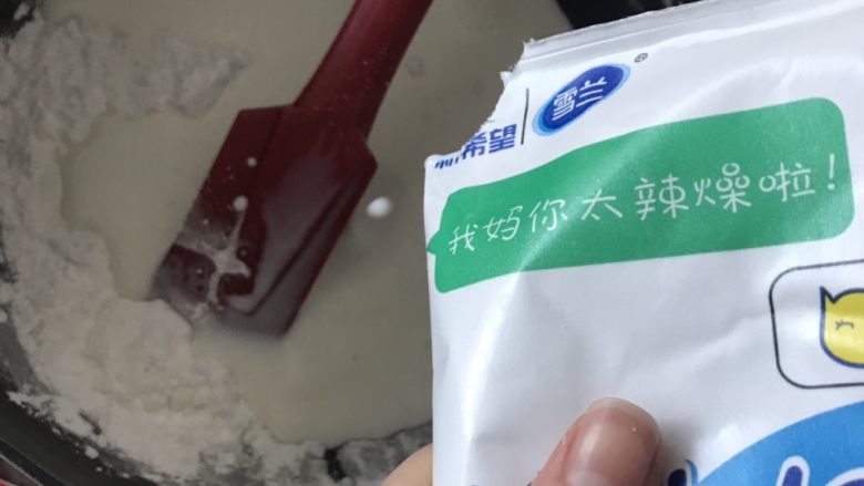 好吃的鲜奶麻薯,炒好的粉类离火,加入牛奶,搅拌均匀。