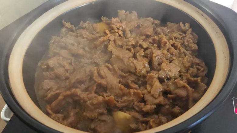 牛肉芋头煲,把炒好的牛肉倒到芋头上面,盖上盖子,中火再炖5分钟。