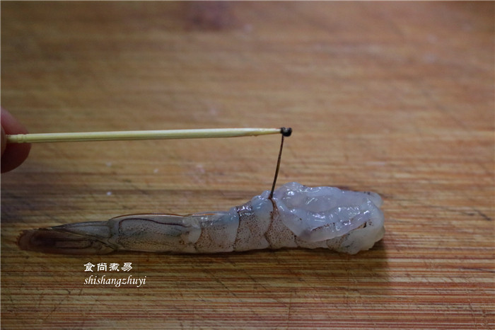 凤尾虾球,切去虾头,剥开虾壳,留尾巴最后一节不要剥,在虾背上竖着切一刀,用牙签挑出虾肠。