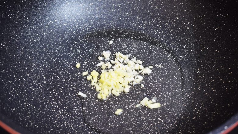 番茄金针菇肥牛,锅中倒入适量的食用油烧热,再放入蒜末和姜末炒出香味