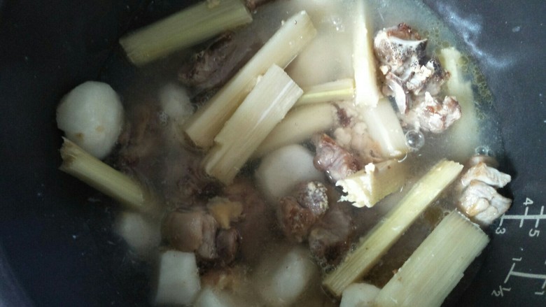 焖羊肉,放入浸过羊肉的水,盖好锅煮到电饭煲提示煮好,再按一次煮饭键煮一次直到羊肉煮软。