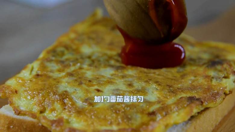 鸡蛋牛肉三明治,煎好的牛肉糜覆在吐司上,加1勺番茄酱抹匀。
再拿一片吐司盖住。