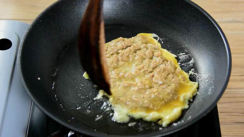 鸡蛋牛肉三明治,拌好的鸡蛋牛肉糜倒入锅中小火煎熟。