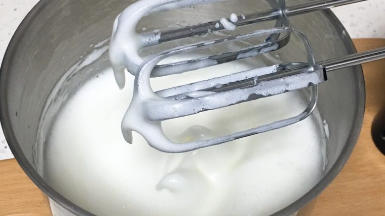 桑椹蛋糕卷,打蛋器高速搅打50圈,蛋白有下垂的弯钩,颜色变白,加入15克细砂糖。