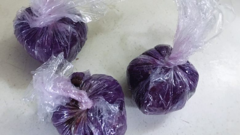颜色艳丽的紫薯茶巾绞,给餐桌上加点不一样的色彩,用保鲜膜包裹好,接着把保鲜膜四角提起,包住紫薯球拧紧