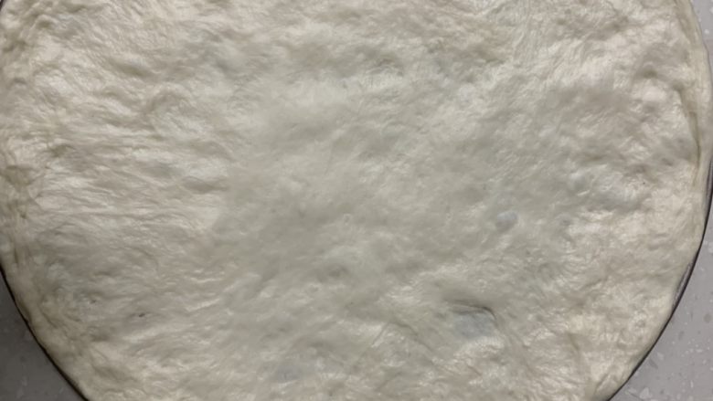 意式芝士牛肉肠彩蔬薄披萨,,这是普通8寸披萨的量,我喜欢吃薄披萨,用了10寸披萨模具。将发酵好的面团放入沿着模具,用手直接揉出披萨饼皮坯。
