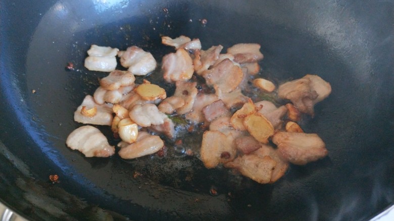 新文美食 麻辣椒香爆炒西芹,锅中放入适量油烧热,放入五花肉炒出油,放入适量葱姜蒜炒香。