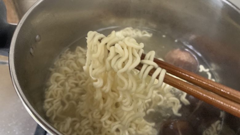烤肠鸡蛋麻辣牛骨汤面,彩蔬煮熟后捞出,留下香菇和着方便面一起煮熟,煮熟的方便面变软、散开即可关火。