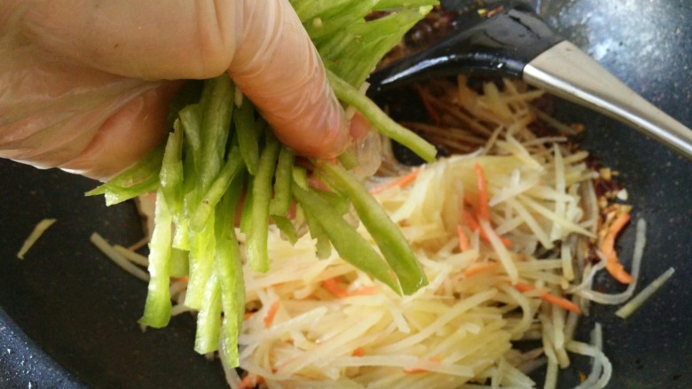鱼香土豆丝,接着加入辣椒丝炒匀