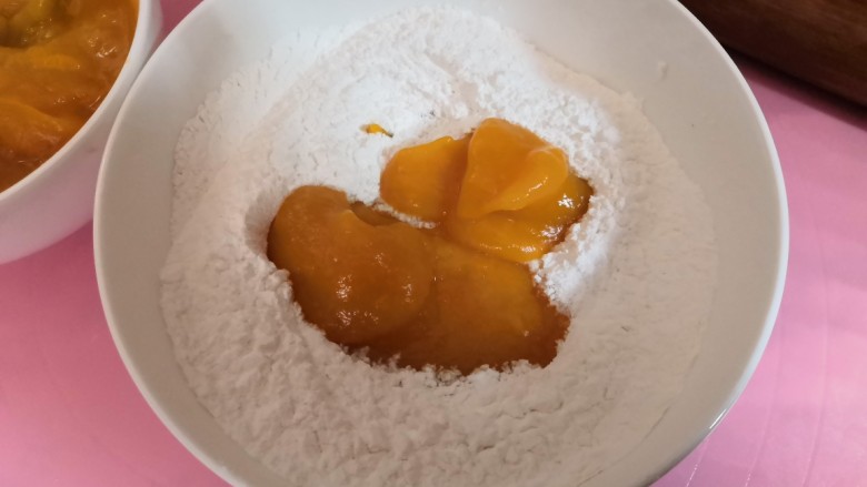 南瓜饼,把蒸熟的南瓜泥一边倒入碗中,用筷子一边搅拌。