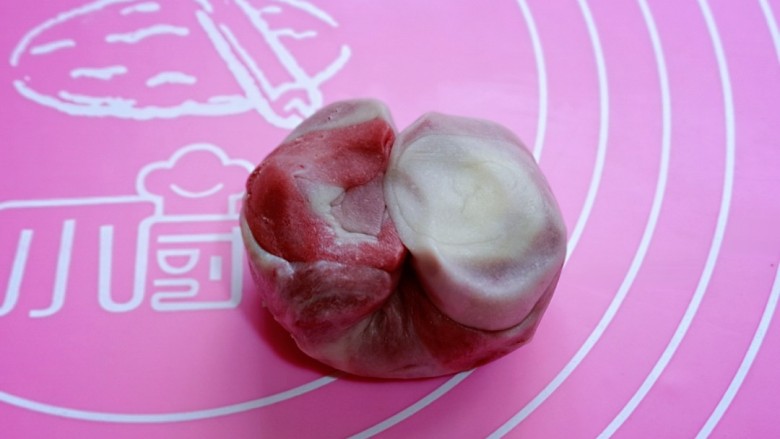 中式甜点~蜜豆桃花酥,把松弛好的面卷,取一个从中间对折一下,用手把面团摁扁。
