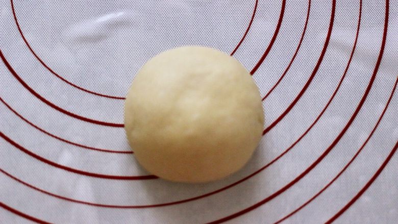 椰蓉奶香面包圈,收口收紧捏实向下,轻轻压扁。