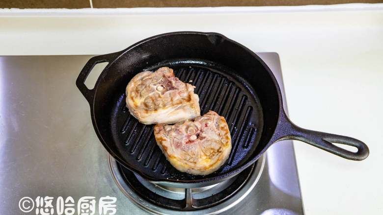 煎羊排,煎一分钟后翻面,再煎一分钟后转中火煎。