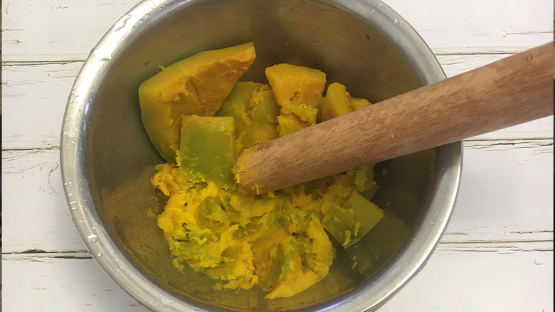 红豆南瓜饼,将蒸熟的南瓜放在盆中,用擀面杖捣成泥