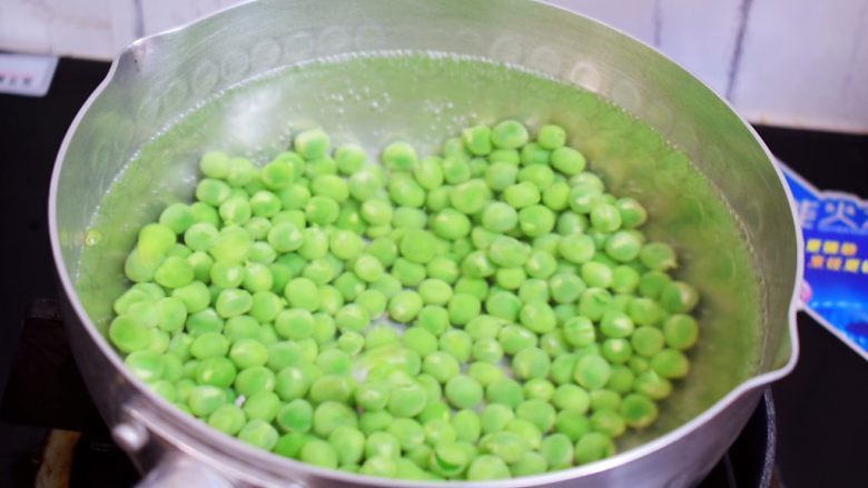 豌豆炒肉丁,锅中倒入适量的水烧开,再放入豌豆