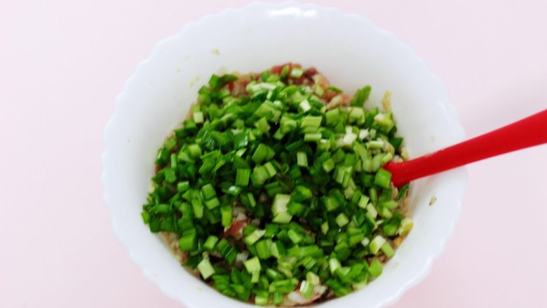 白菜海虹肉丁饺子,韭菜用刀切成碎末,加入馅料中。