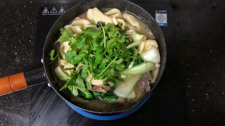 河南小吃-羊肉烩面,20、最后撒上香菜段和蒜苗粒,淋上少许香油即可。