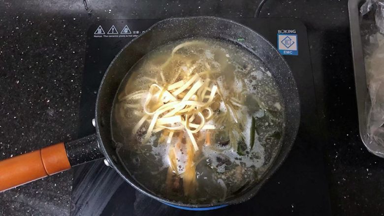河南小吃-羊肉烩面,16、放入海带丝、粉条、黑木耳、豆腐丝、黄花菜。