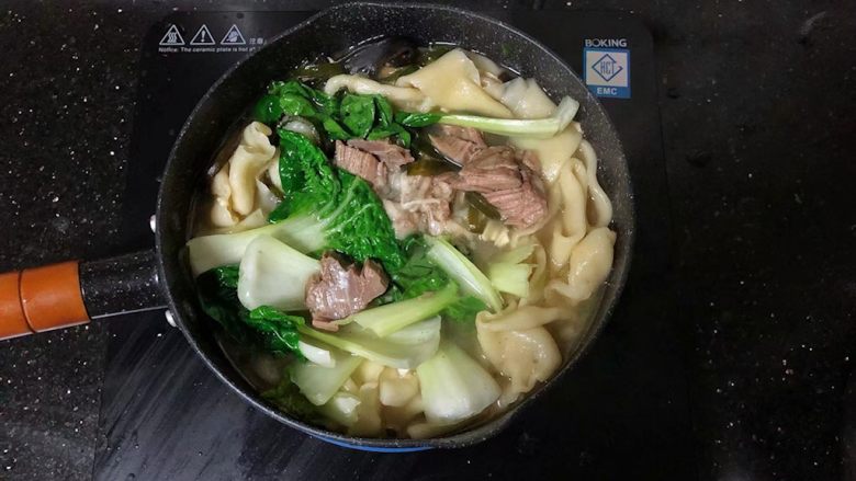 河南小吃-羊肉烩面,19、放入青菜,烹入少许的盐调味。